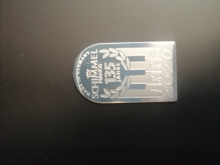 Schimmel Pianos Jubiläumsplakette 135 Jahre 1885-2020 auf schwarzem Hintergrund