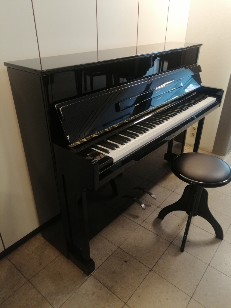 Schwarzes Klavier mit Klavierhocker in einem Raum, aufgenommen am 28.08.2026