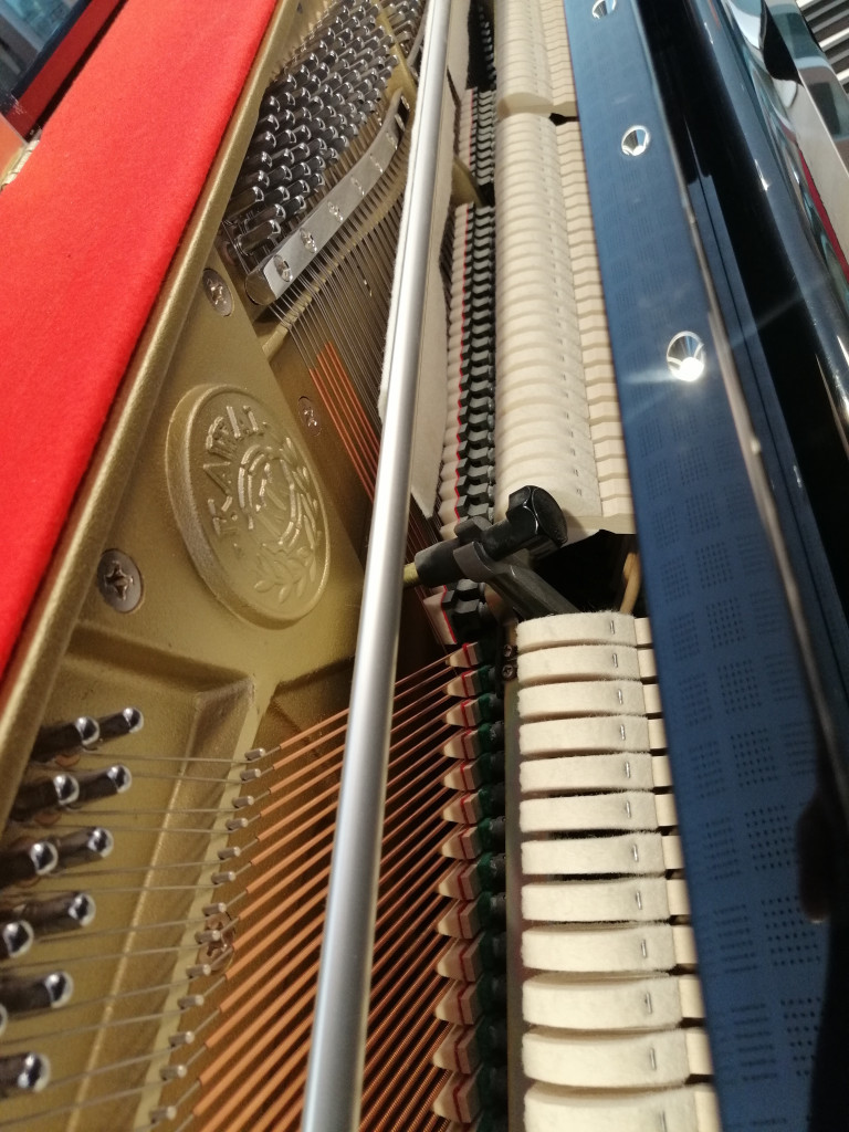 Detailansicht des Innenlebens eines Klaviers mit Saiten und Mechanik