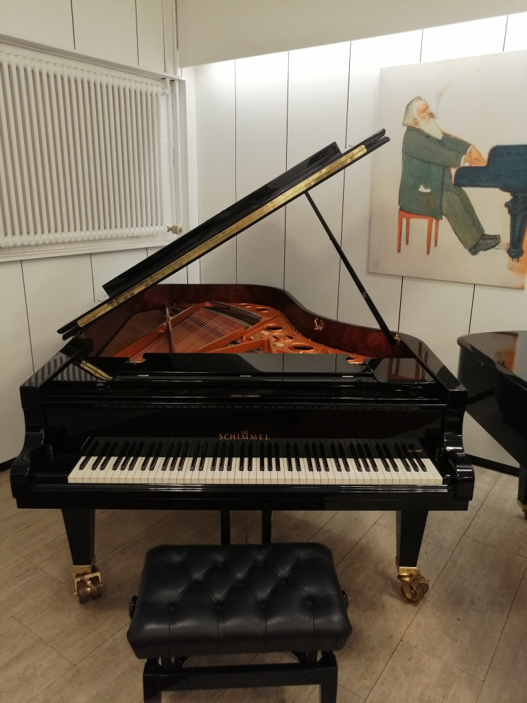 Schimmel Flügel im Musikraum mit Gemälde – img-20260829-104031.jpg Flügel der Marke Schimmel in einem Musikraum mit Gemälde im Hintergrund