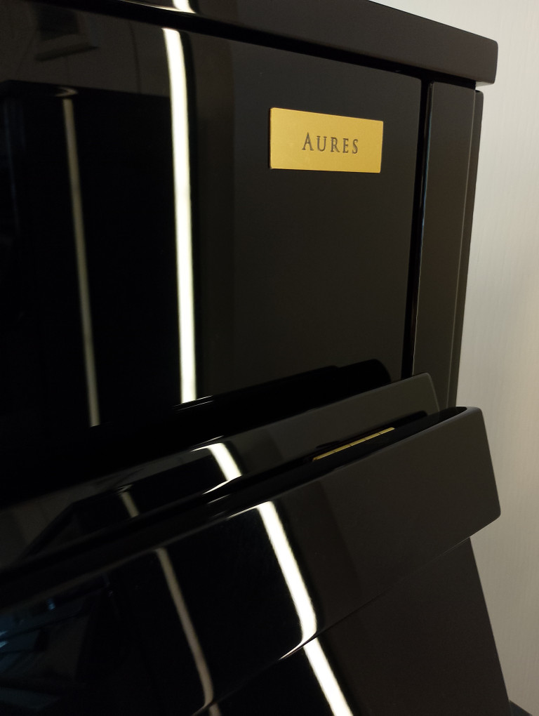 AURES Gerät in Schwarz mit goldfarbenem Namensschild – modernes technisches Design Schwarzes AURES-Gerät mit goldfarbenem Namensschild, modernes Design