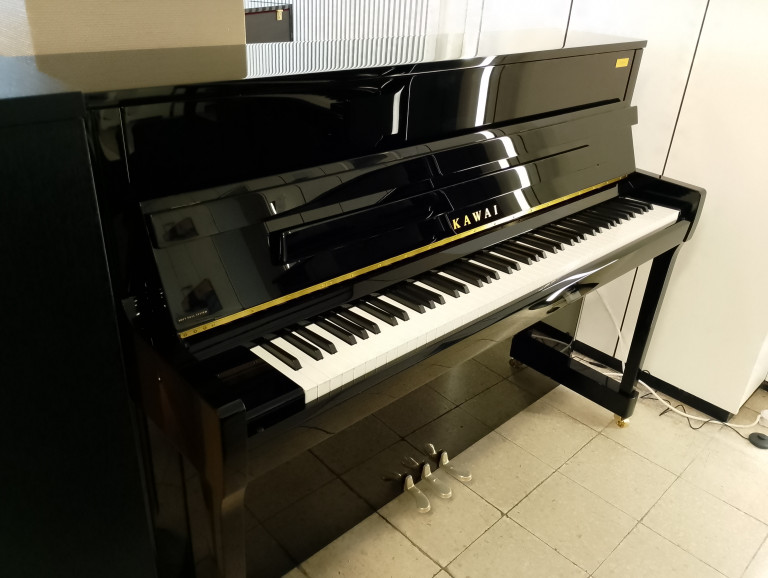 Kawai Klavier – schwarzes Klavier auf Fliesenboden im Musikraum Schwarzes Kawai Klavier in einem Musikraum auf Fliesenboden