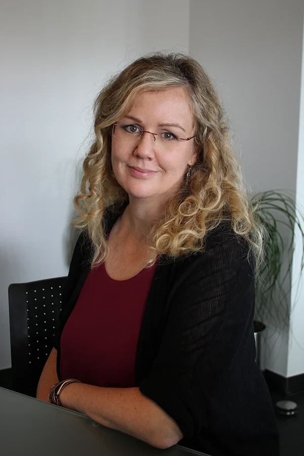 Portrait von Nicole Wende mit lockigem blondem Haar und rotem Oberteil