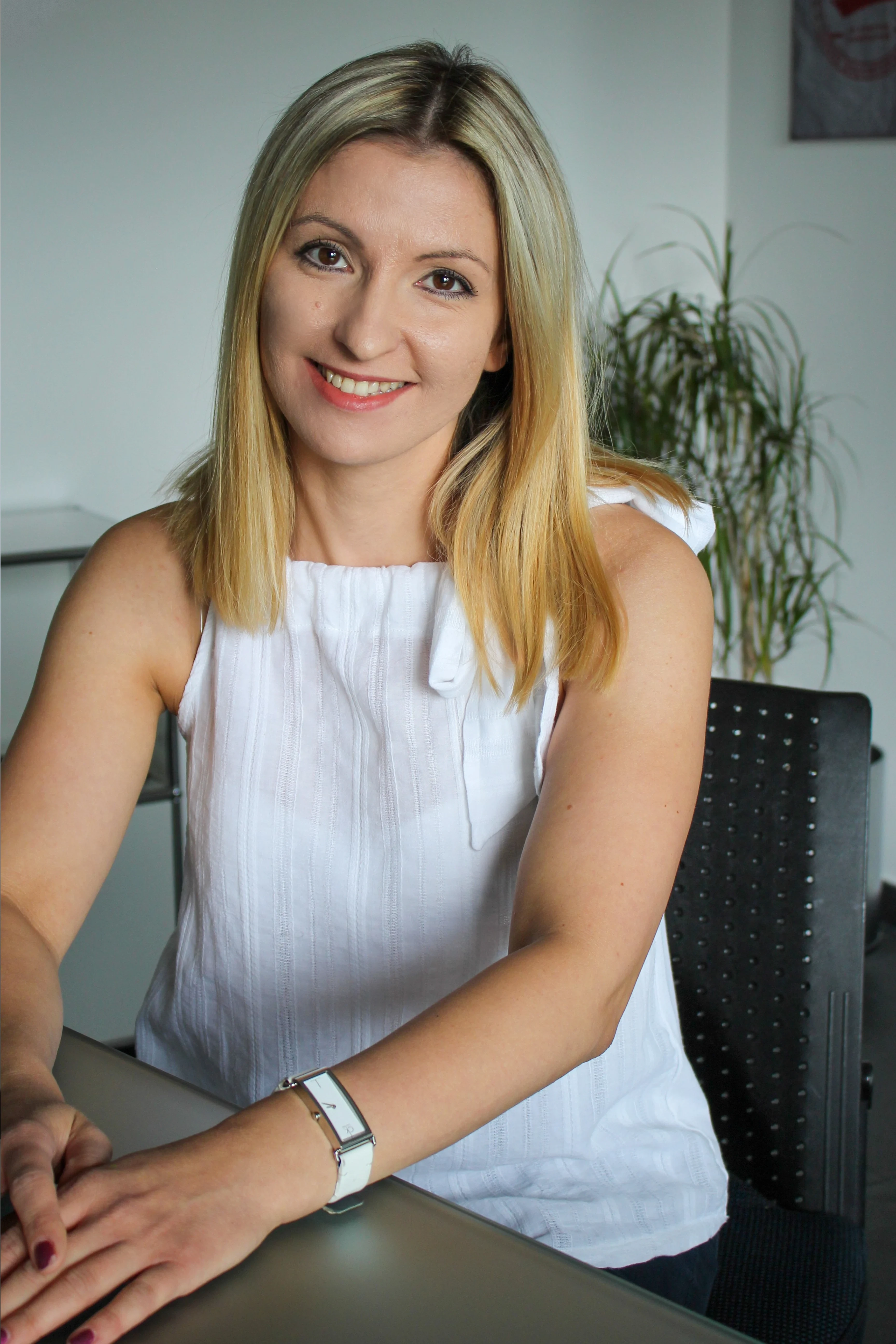 Olena Mazur im Büro mit weißer Bluse und blondem Haar