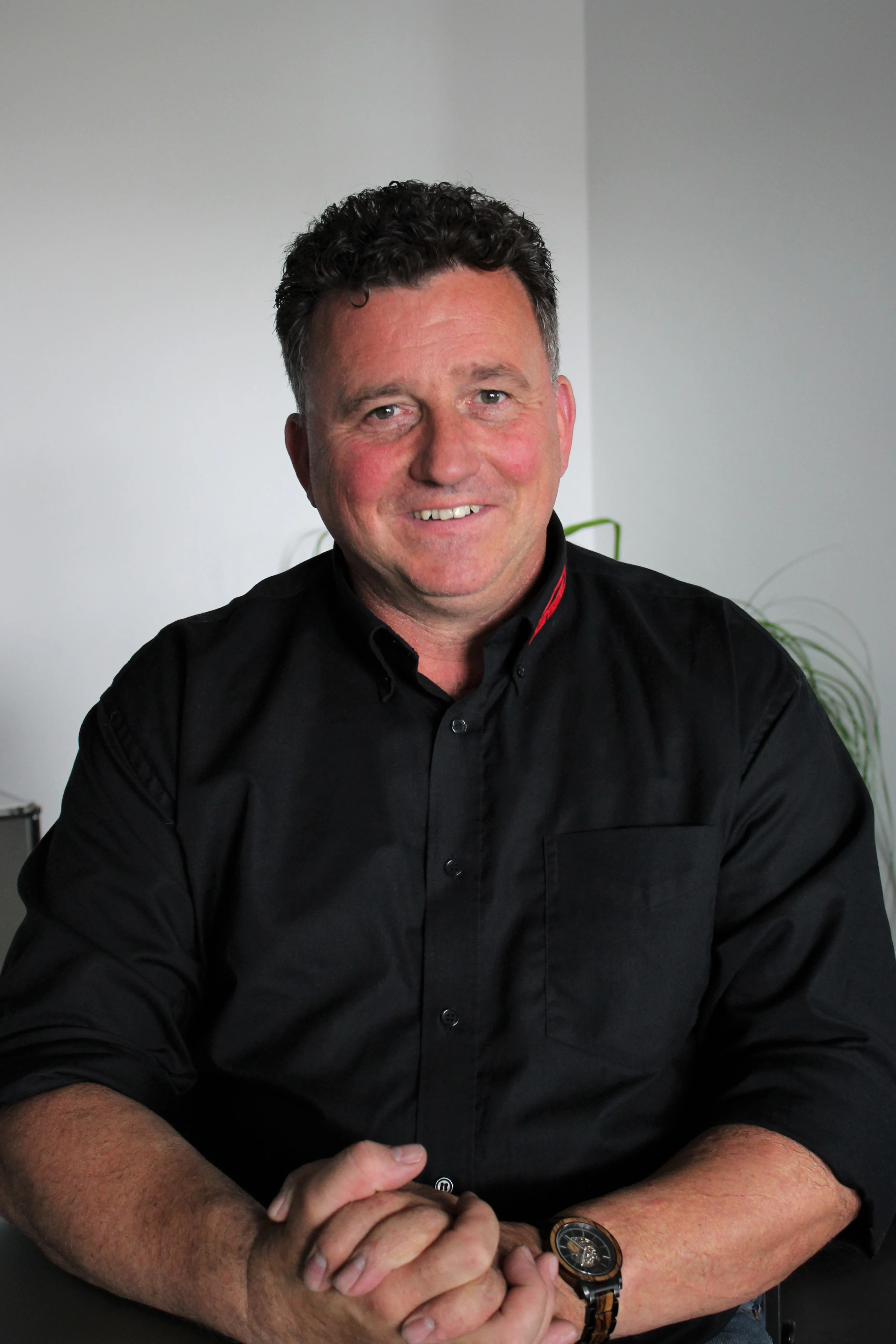 Thorsten Windemuth in schwarzem Hemd vor hellem Hintergrund