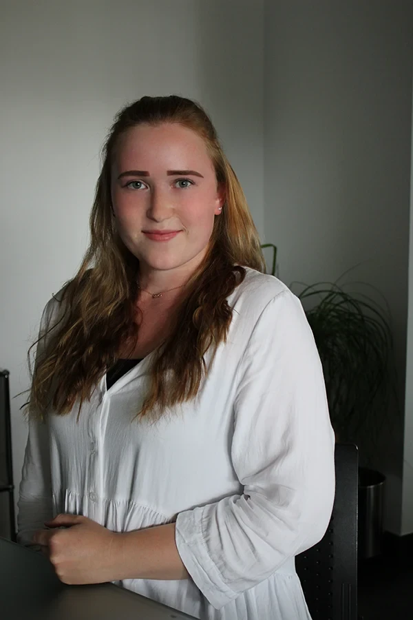 Maria Klingner in weißer Bluse vor neutralem Hintergrund