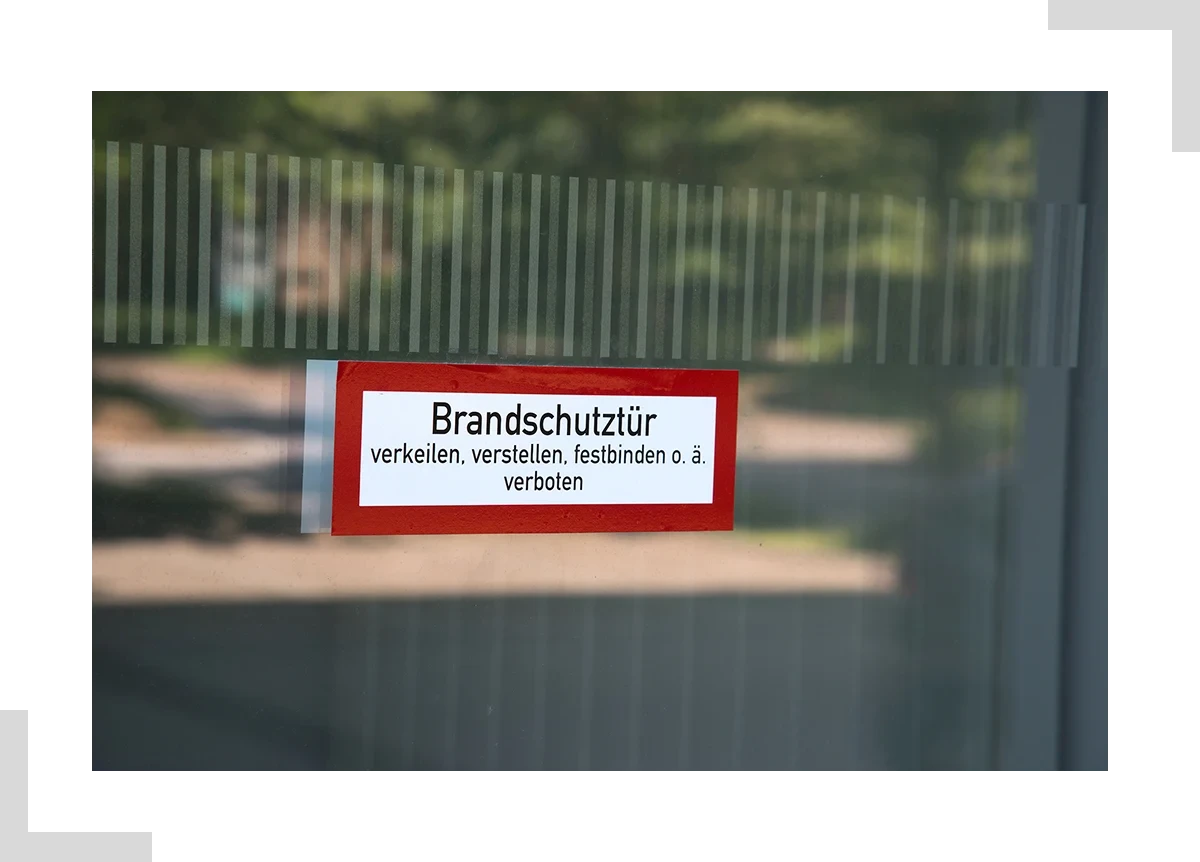 Brandschutztür mit Warnschild: Verkeilen, Verstellen und Festbinden verboten