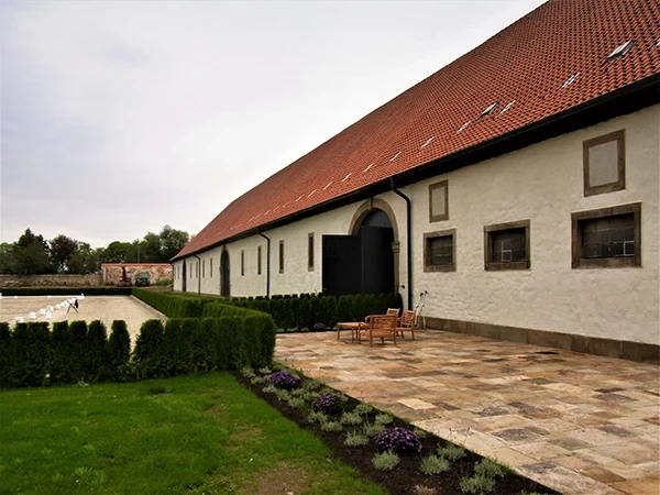Außenansicht eines sanierten Gutshauses mit Terrasse und Garten