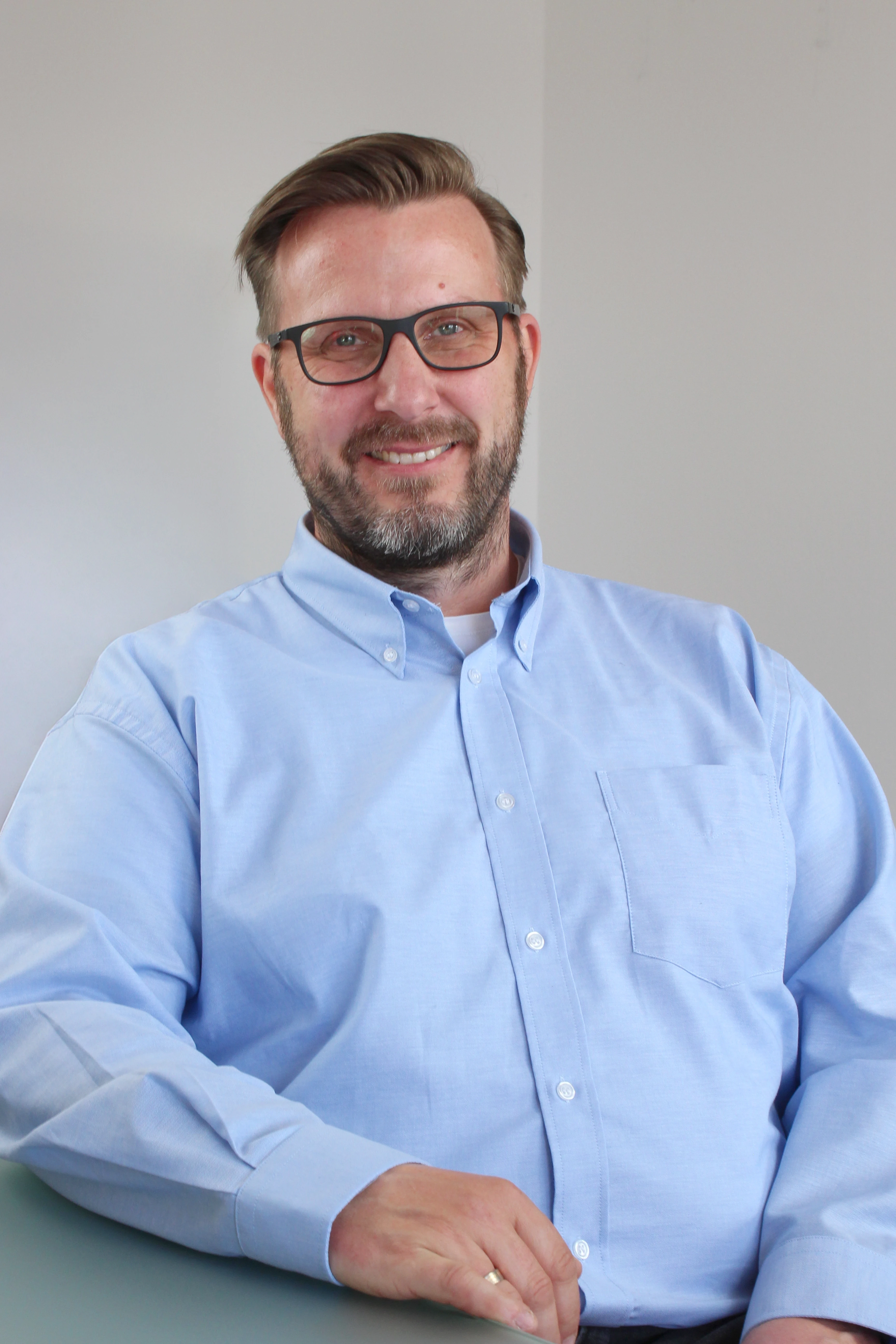 Porträt von Mirko Meineke mit Brille und blauem Hemd