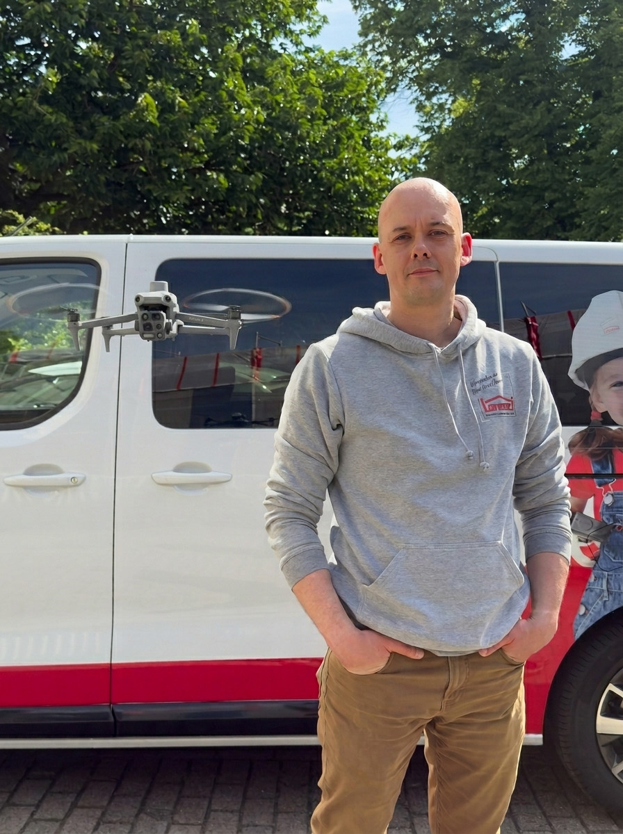 Mann mit Drohne vor Transporter der Firma LORENZ Bau