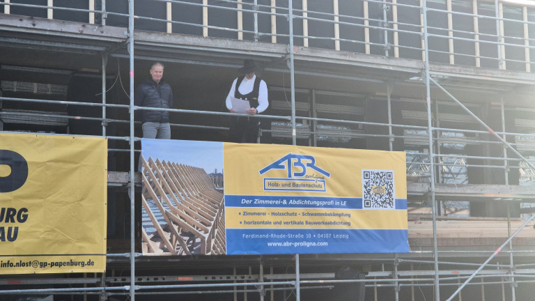 Zimmerei ABR Proligna Holz- und Bautenschutz auf Baustelle in Leipzig mit Banner und Handwerker