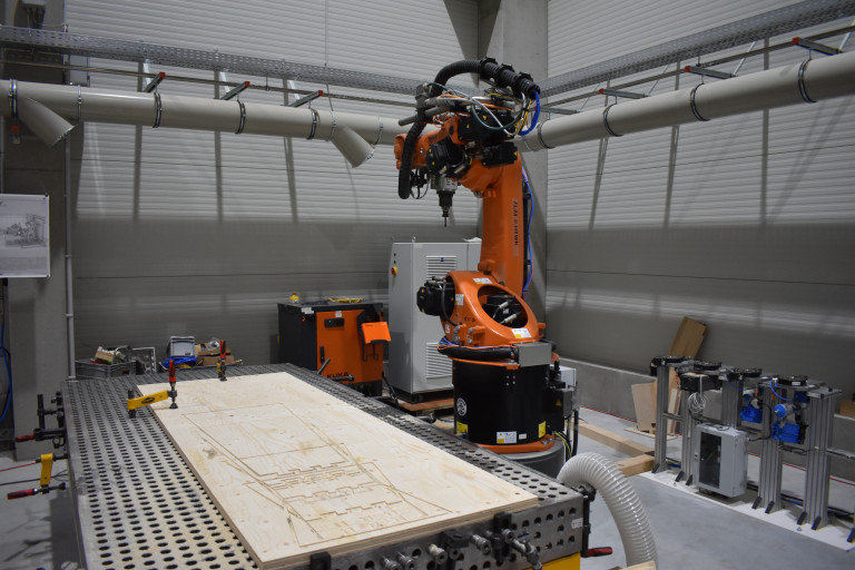 Industrieroboter KUKA bei der Holzbearbeitung in moderner Werkhalle