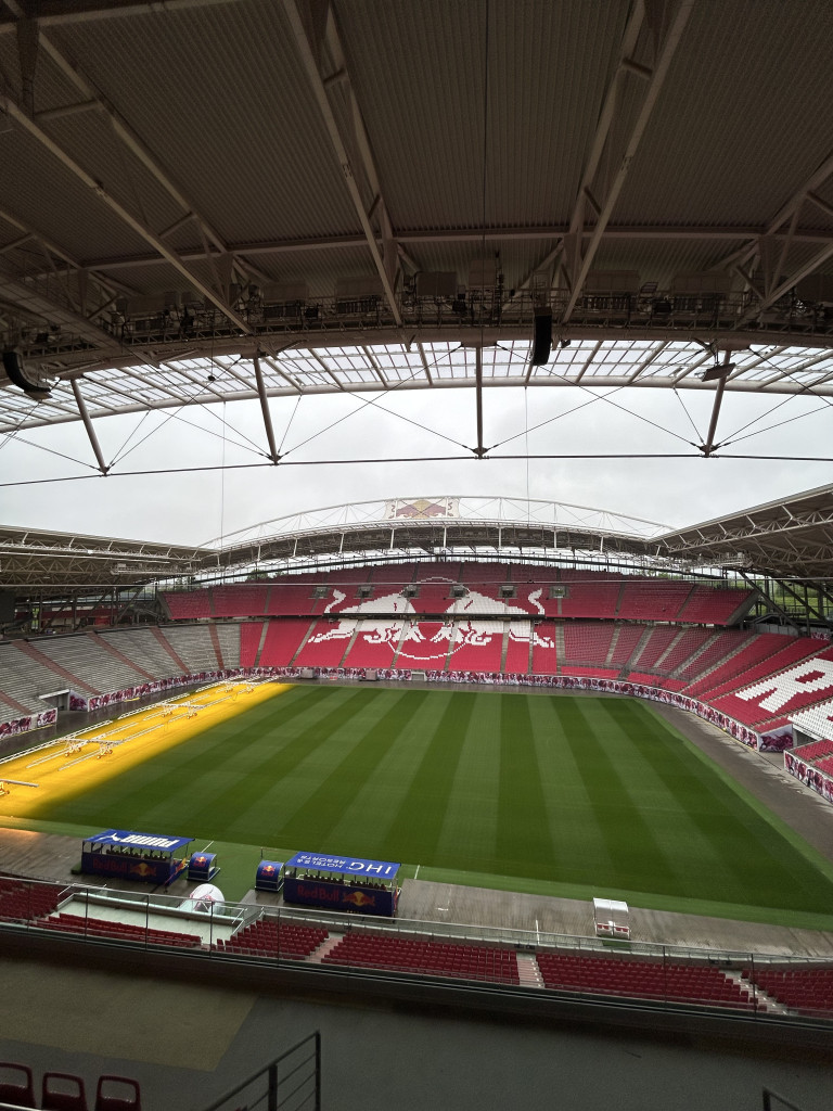 Leeres Fußballstadion mit Red Bull Symbolen auf den Tribünen, wahrscheinlich Red Bull Arena Leipzig