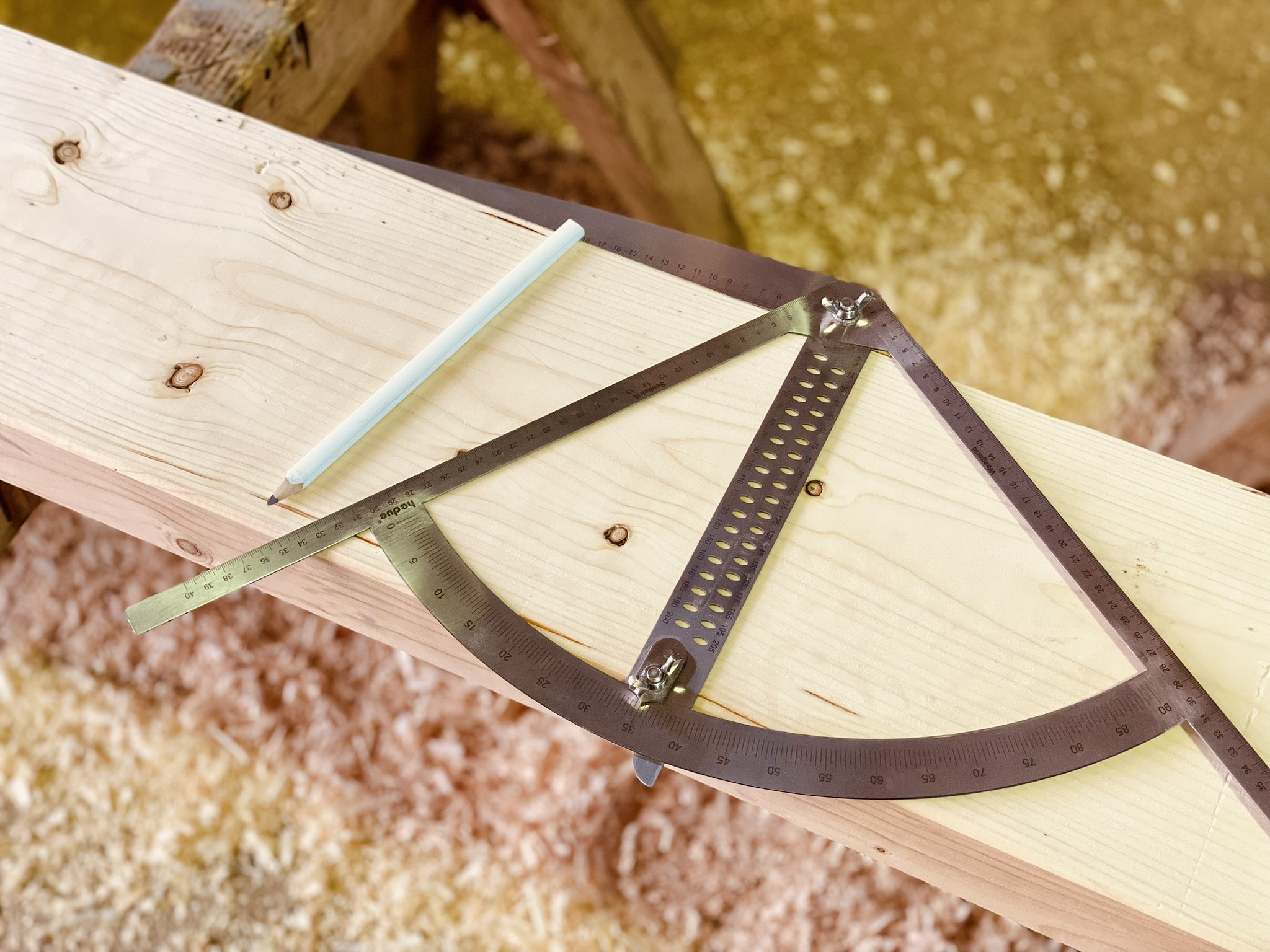 Holzbearbeitung: Metallwinkel und Bleistift auf Holzbrett in einer Werkstatt