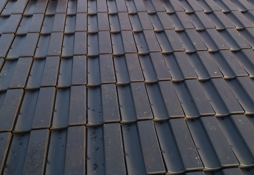 Nahaufnahme von modernen schwarzen Dachziegeln auf einem Hausdach, aufgenommen am 21.01.2026