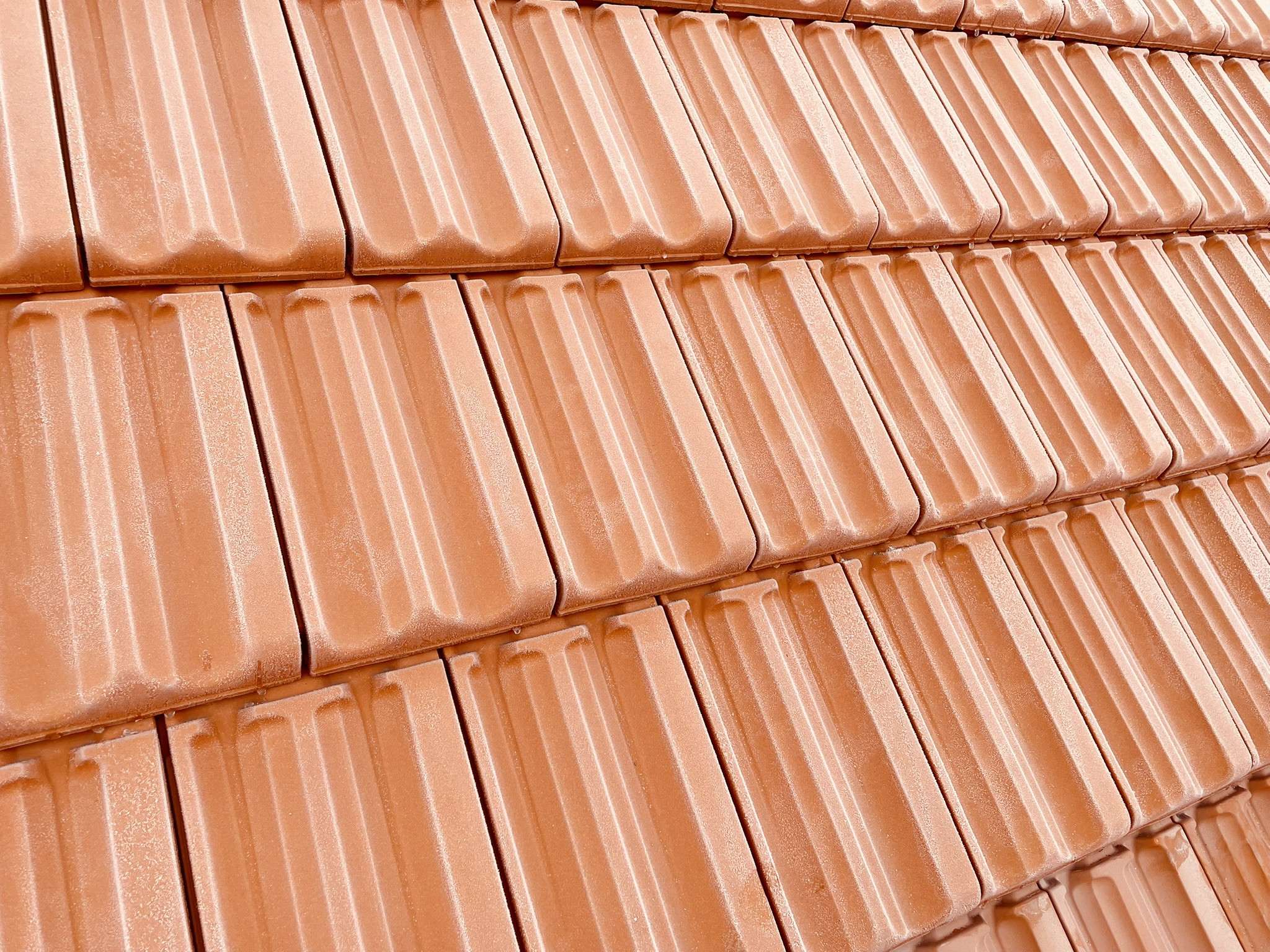 Nahaufnahme von neuen roten Dachziegeln auf einem Dach