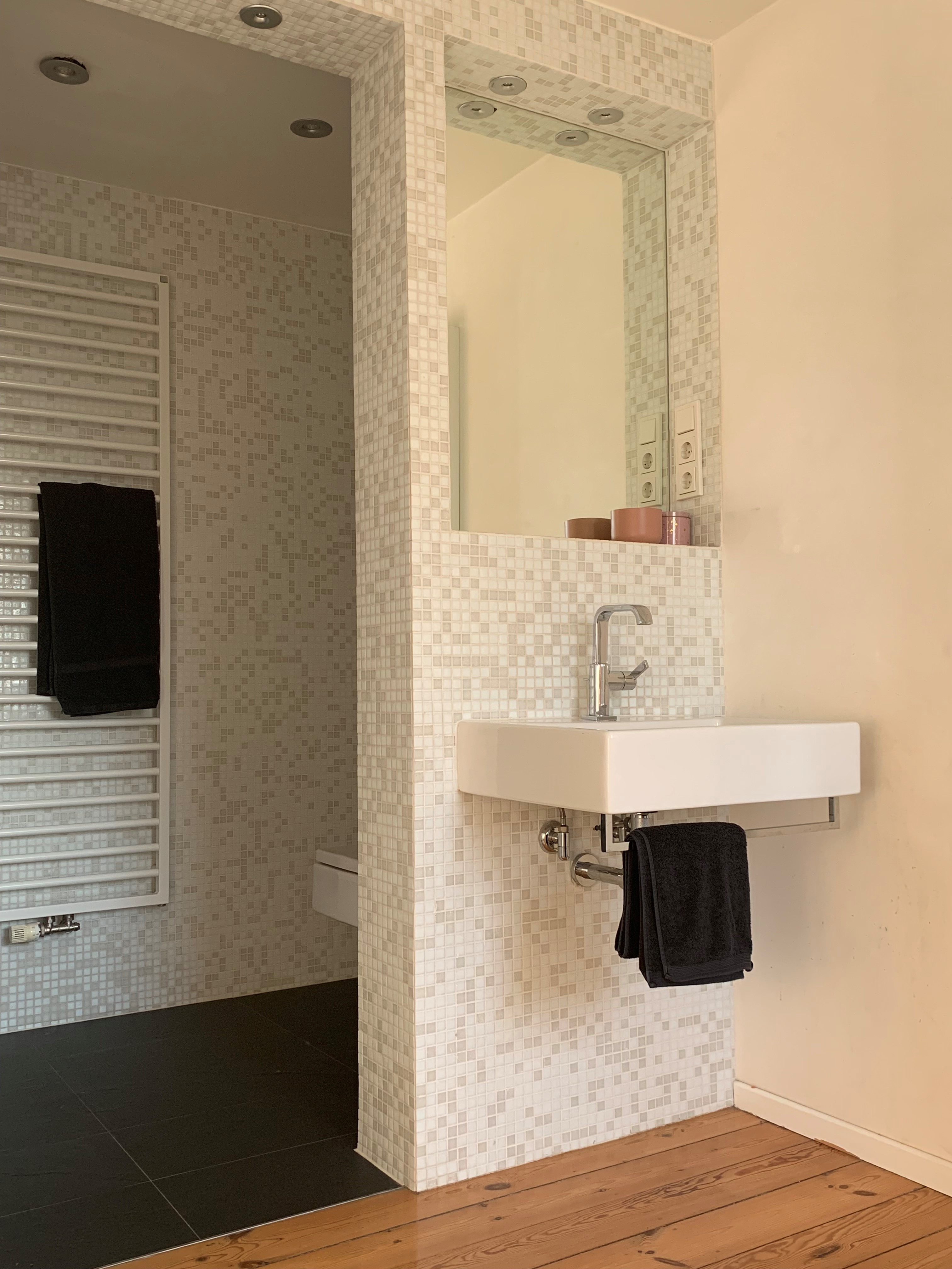 Modernes Badezimmer mit Waschbecken, Handtuch und Mosaikfliesen