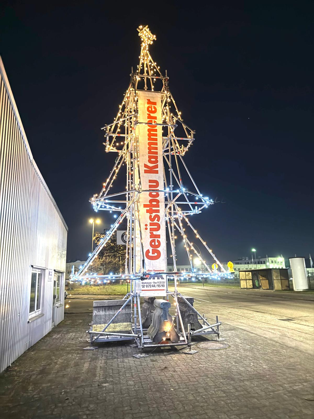 Weihnachtsbaum aus Gerüstmaterial mit Beleuchtung vor dem Gebäude von Gerüstbau Kammerer