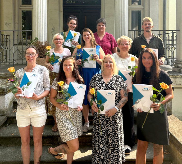Abschluss Erzieher 2023 – Gruppenfoto der Absolventen mit Urkunden und Rosen Gruppenfoto zum Abschluss der Erzieher-Ausbildung, Absolventinnen und Absolventen mit Urkunden und Rosen auf einer Treppe
