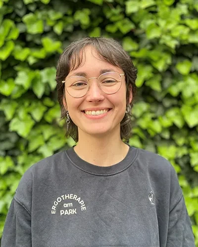 Lotte Kienlin von Ergotherapie am Park vor einer grünen Hecke