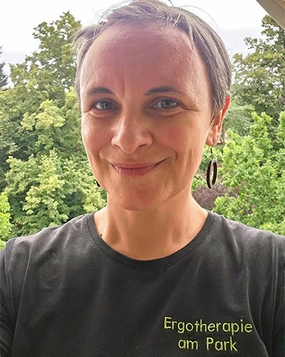Porträt von Claudia Geier vor grünem Hintergrund