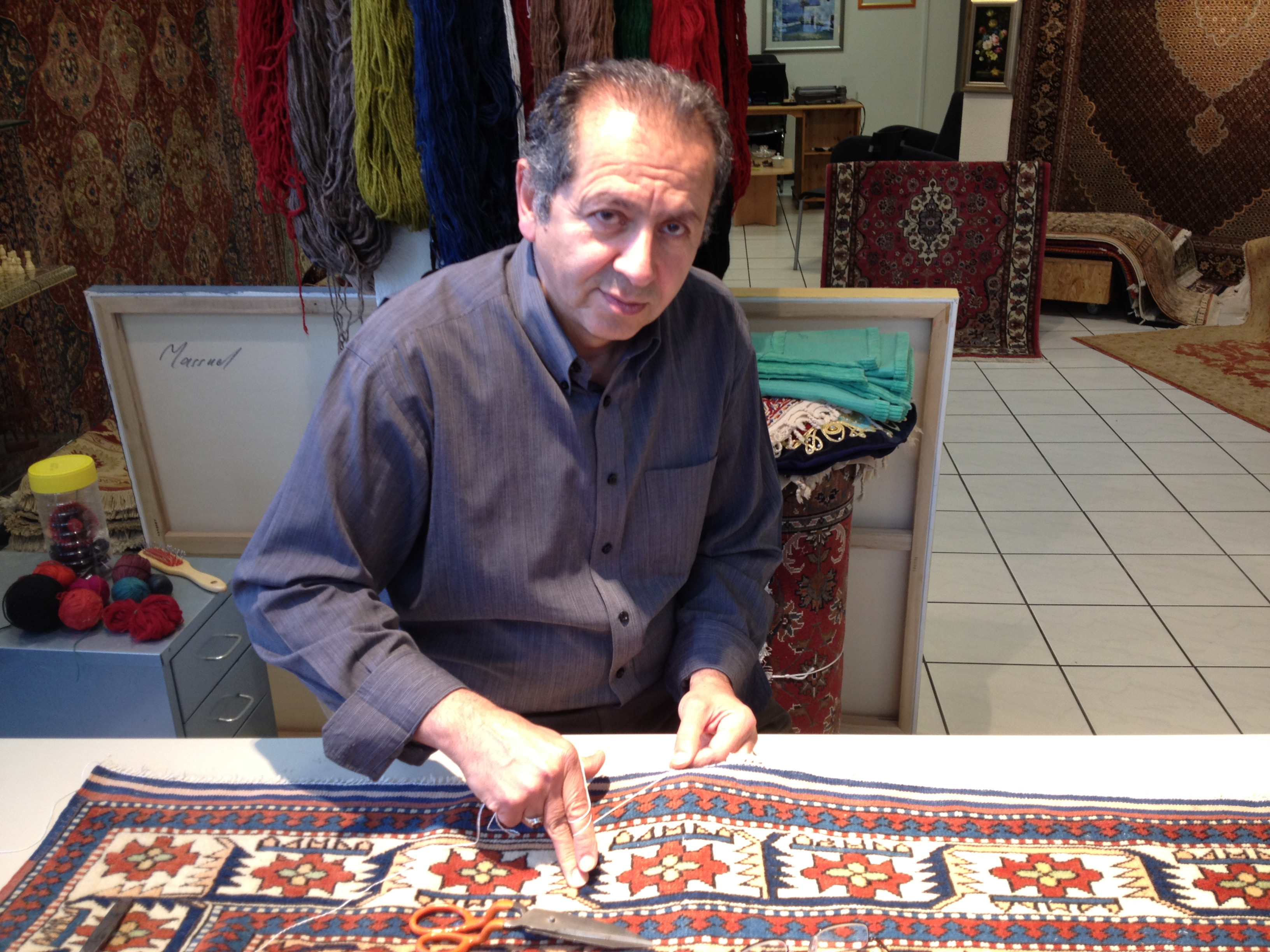 Handarbeit an einem traditionellen Teppich in einem Teppichgeschäft