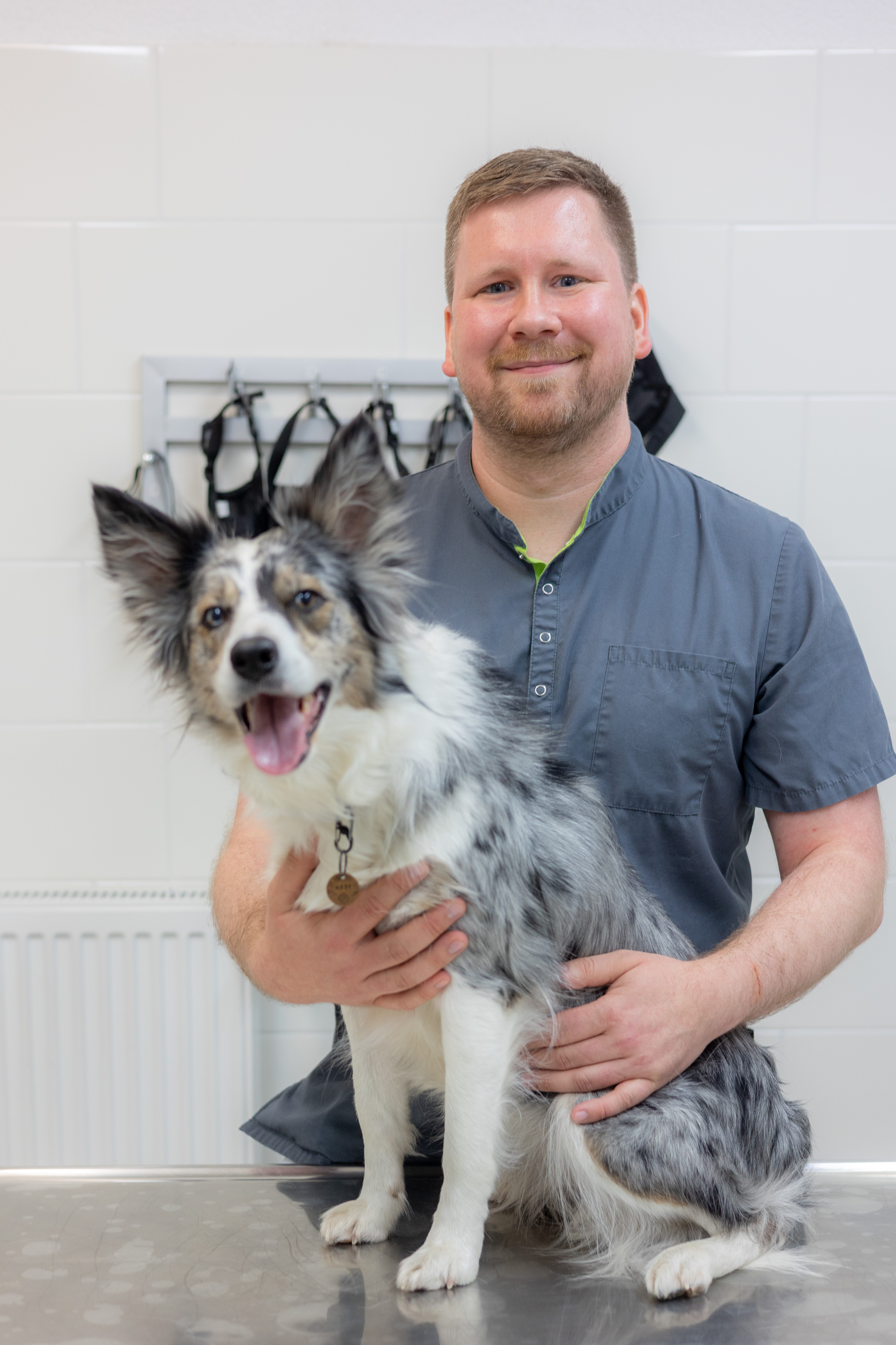 Herr Hein aus dem Team mit Hund in der Tierarztpraxis