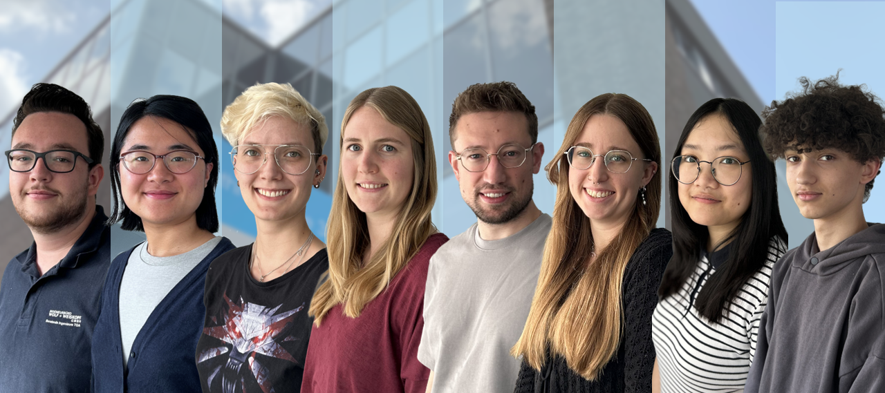 Teamfoto vier Personen vor modernem Glasgebäude – neues Bild Slider v4