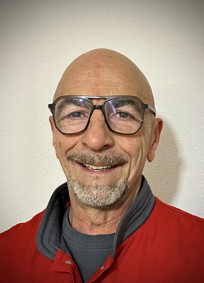 Placidino Staita mit roter Jacke vor heller Wand