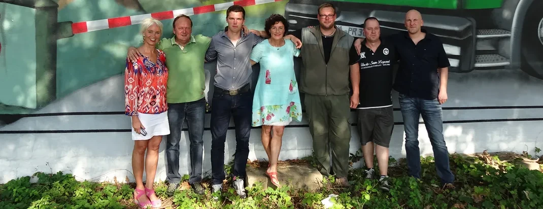 Teamfoto für die Über-uns-Seite – Gruppenbild mehrerer Personen vor Wand