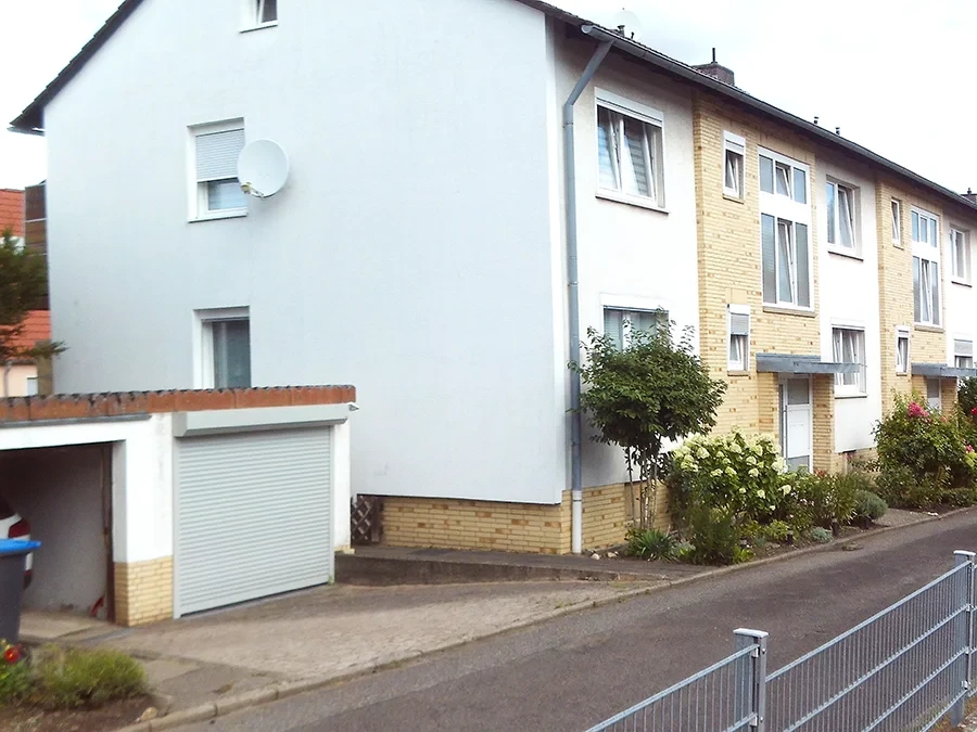 Vorderansicht eines Wohnhauses mit Garage und Vorgarten