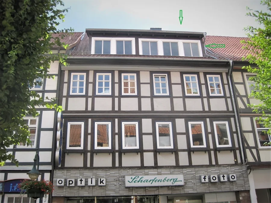 Vorderseite eines Wohn- und Geschäftshauses mit Fachwerkfassade und Optikgeschäft im Erdgeschoss