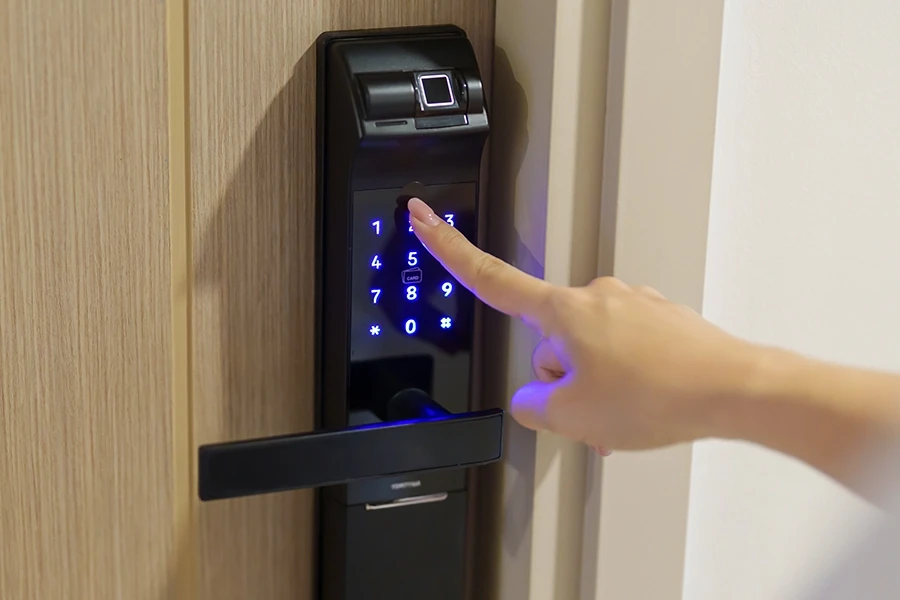 Finger tippt auf beleuchtetes Tastenfeld eines elektronischen Türschlosses