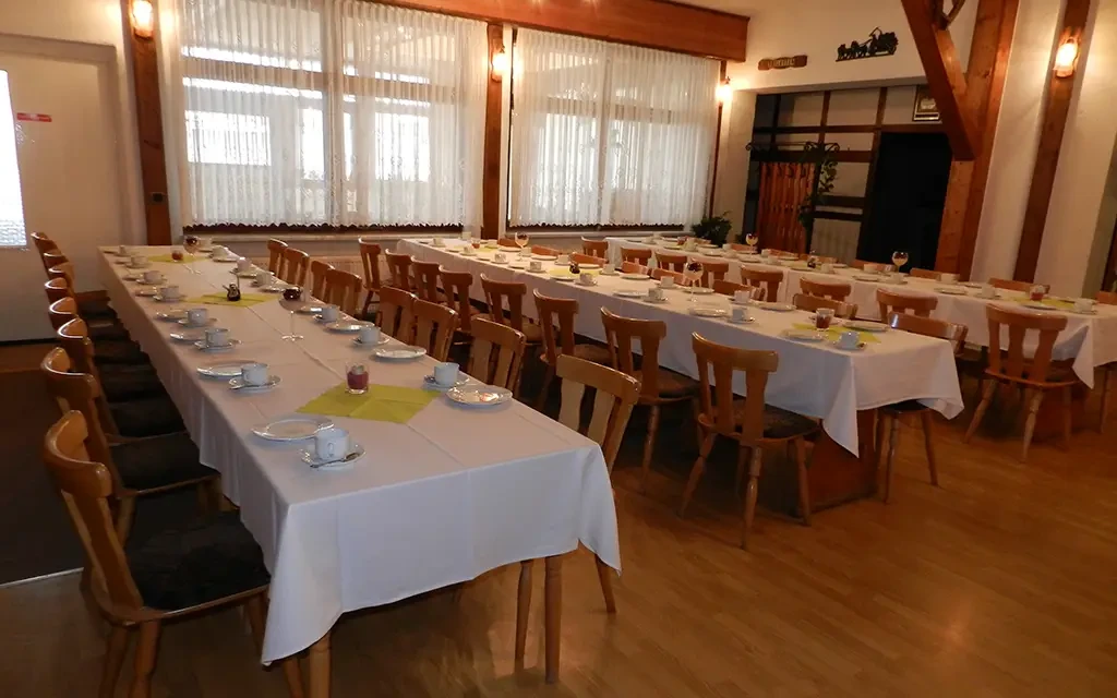 Tagungsraum mit festlich gedeckten Tischen und Stühlen für eine Veranstaltung oder Konferenz