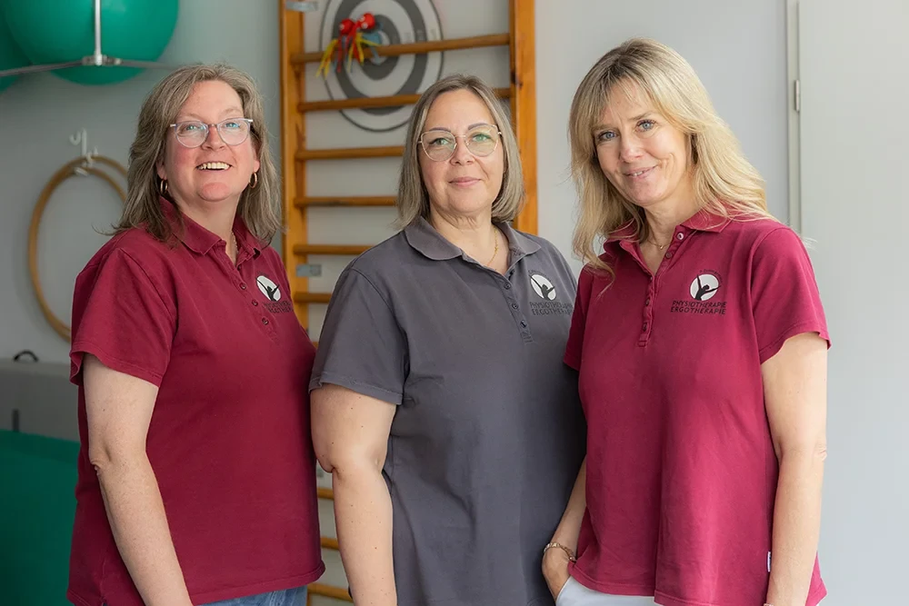 Teamfoto der Physiotherapie und Ergotherapie Praxis, drei Mitarbeiterinnen lächeln in die Kamera