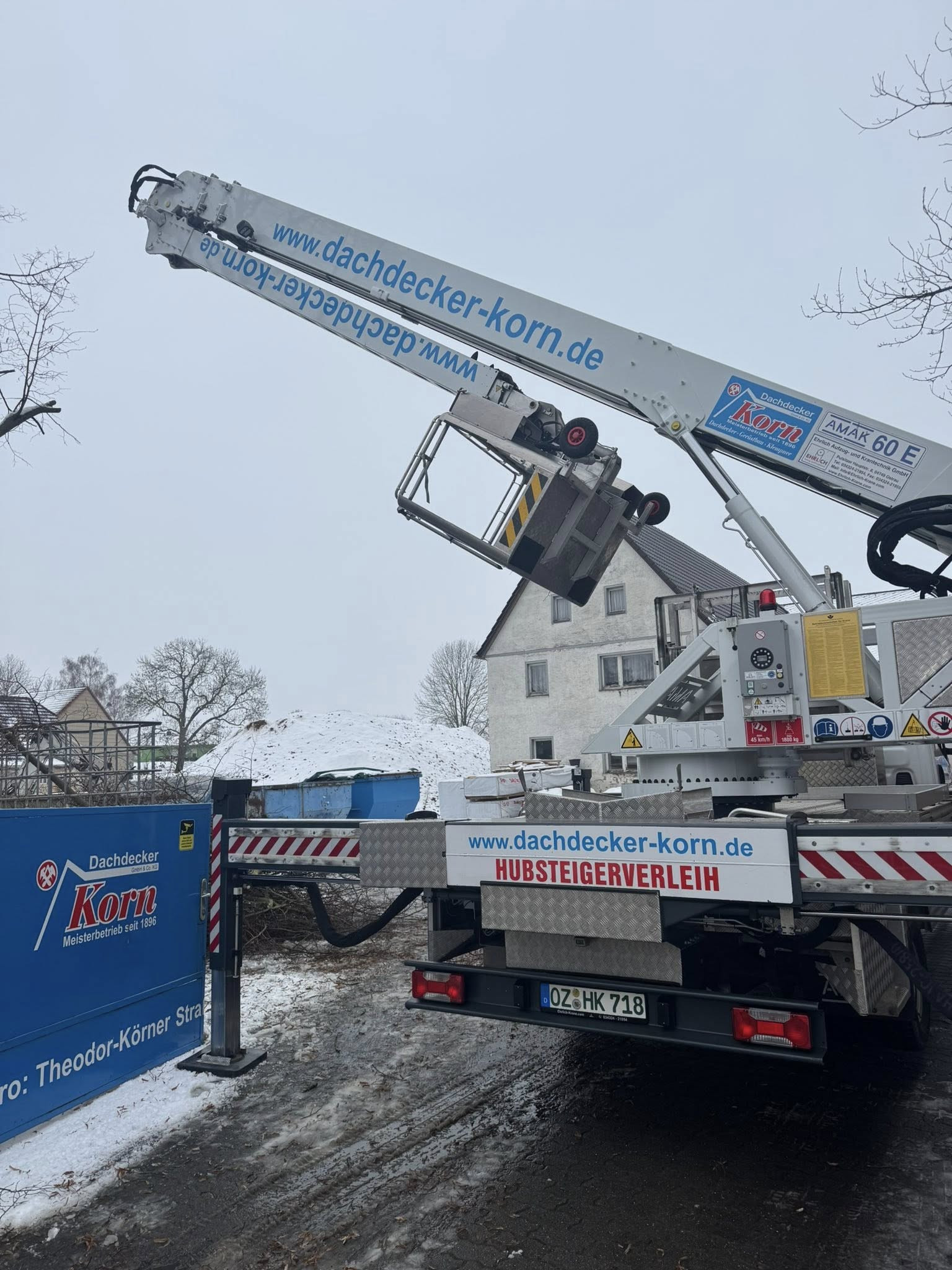 Hubsteigerverleih Dachdecker Korn auf Baustelle im Winter mit Schneebedeckung