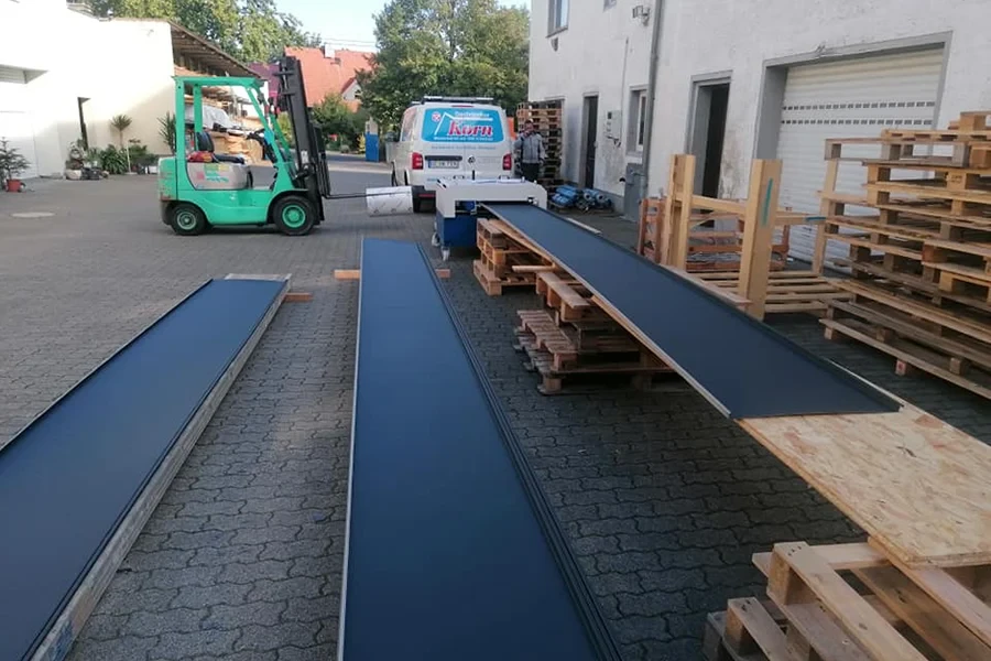 Herstellung von Dachscharre auf einem Betriebshof mit Maschinen und Paletten