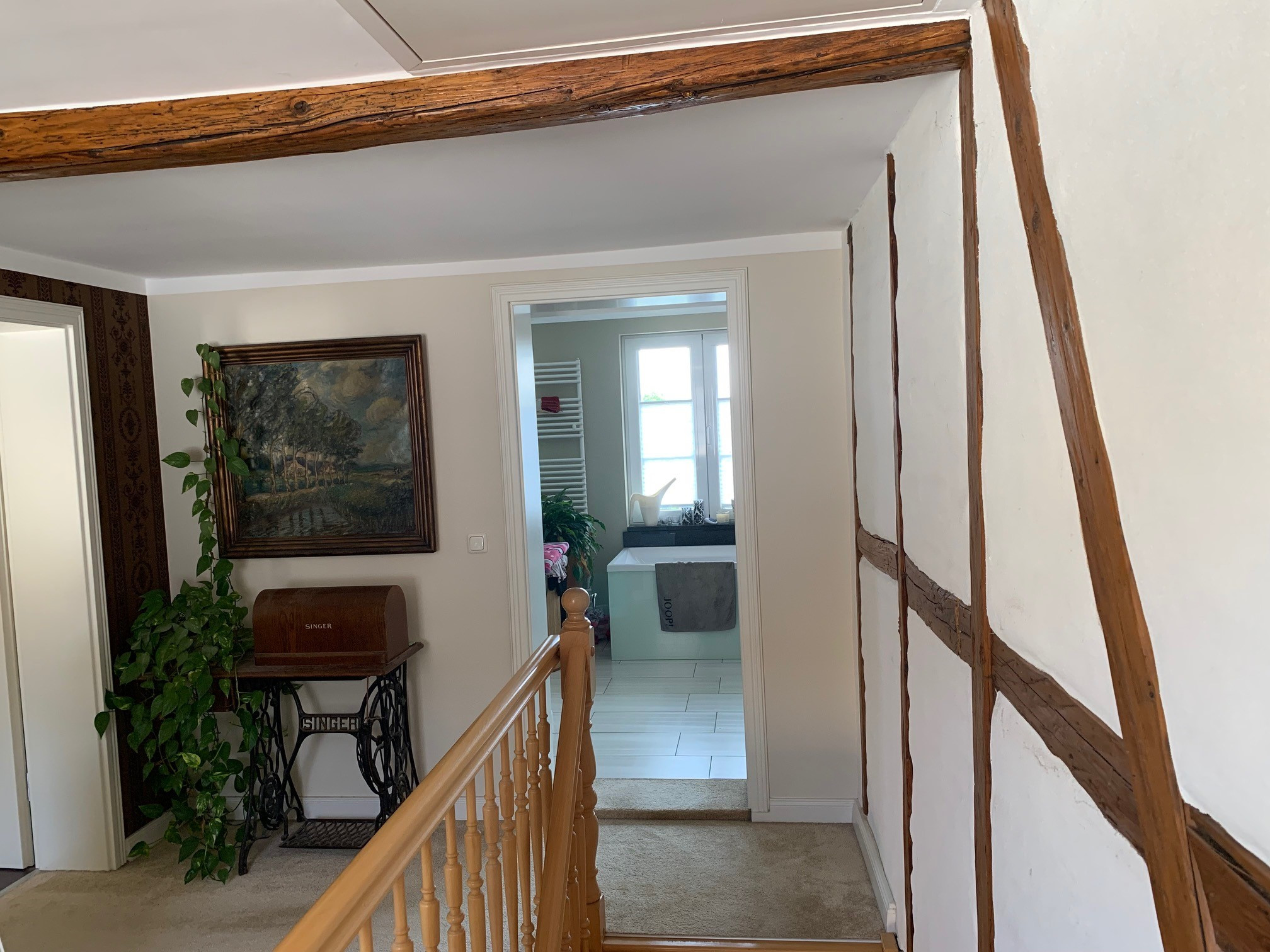Flur mit Blick ins Badezimmer in einem Fachwerkhaus mit Altbau-Charme und antiker Nähmaschine