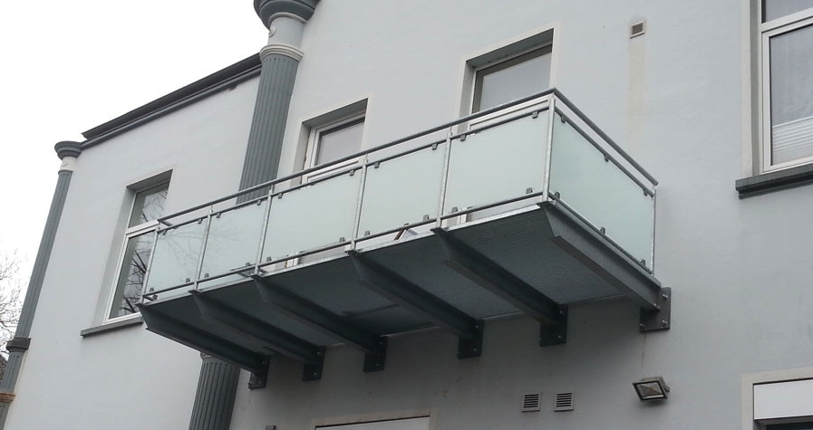 Moderner Balkon mit Handlauf aus Glas und Metall an einem Wohnhaus