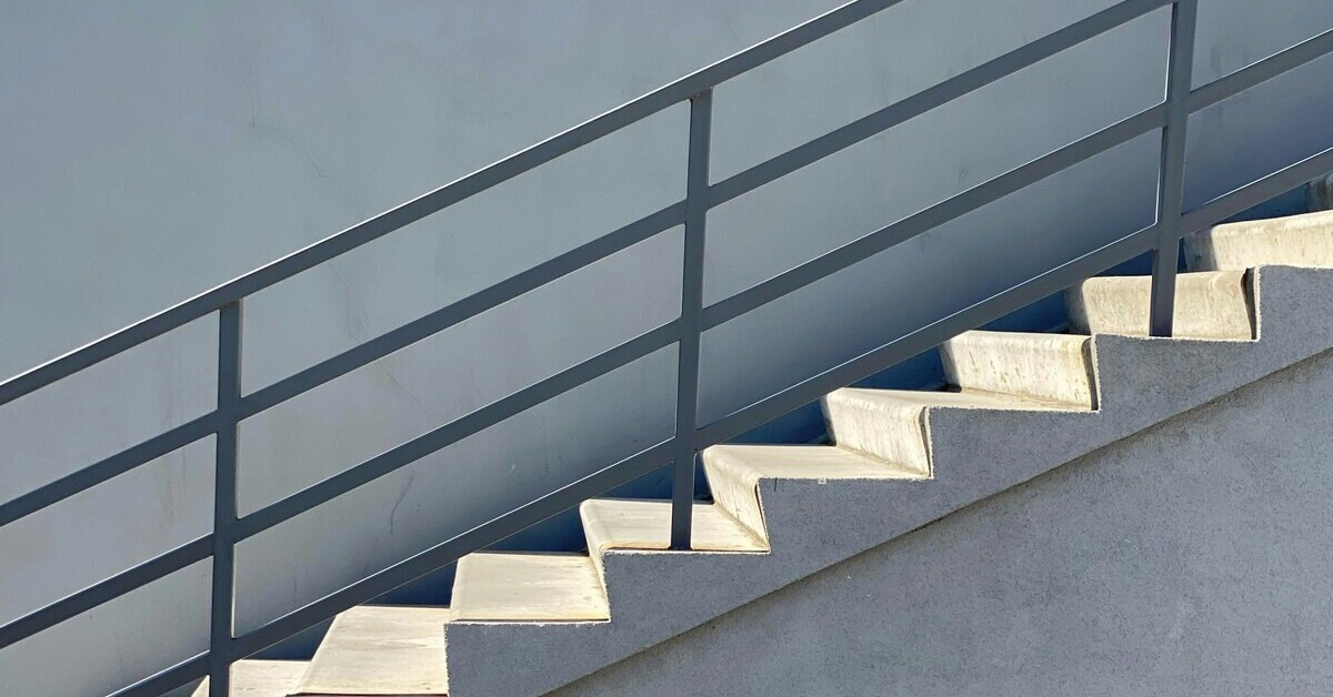 Modernes Treppengeländer aus Metall an einer Betontreppe