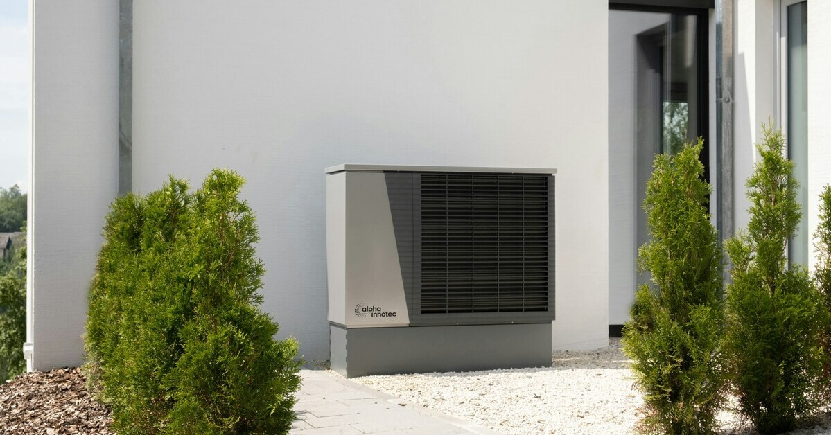 Moderne Wärmepumpe von alpha innotec vor einem Einfamilienhaus