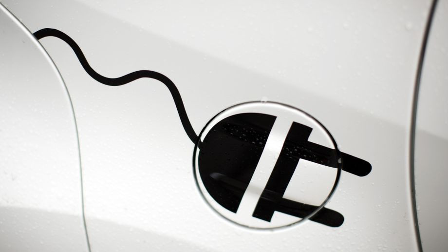 Elektromobilität: Nahaufnahme eines Steckersymbols auf einem Elektroauto Symbol für Elektromobilität auf einem weißen Fahrzeug – Nahaufnahme eines Steckers