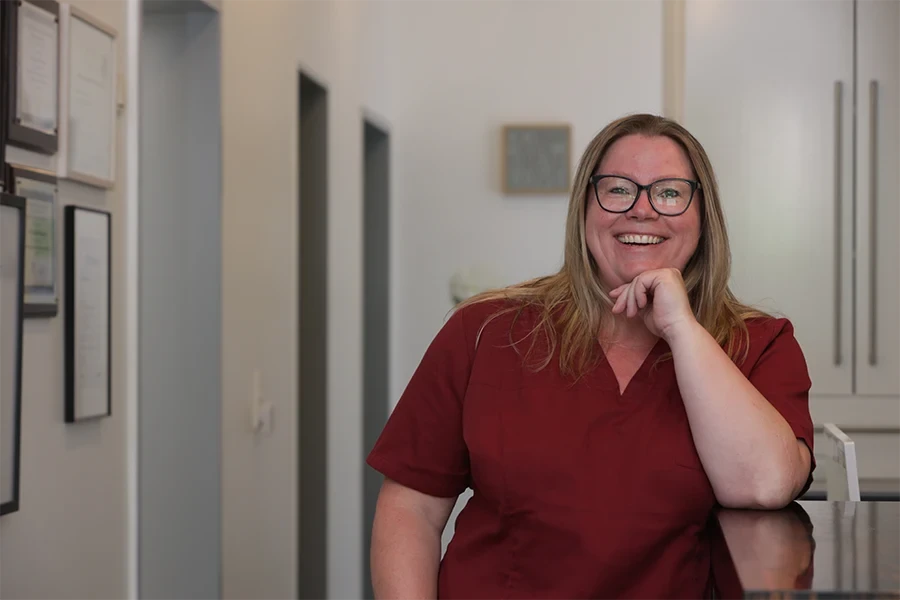 Porträt von Daniela Konnecker in medizinischer Kleidung, lächelnd in einer Praxis