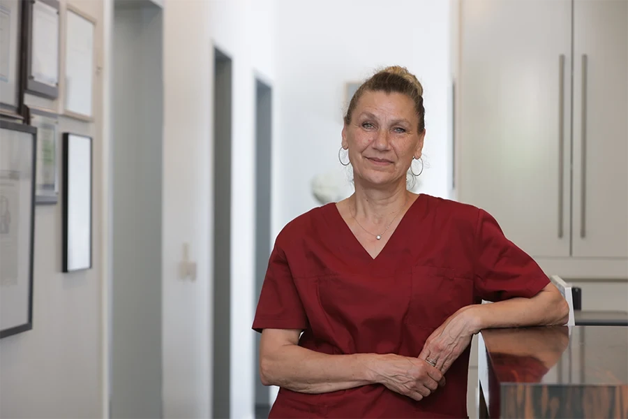 Porträt von Bettina Oessling in medizinischer Arbeitskleidung in einer Praxis