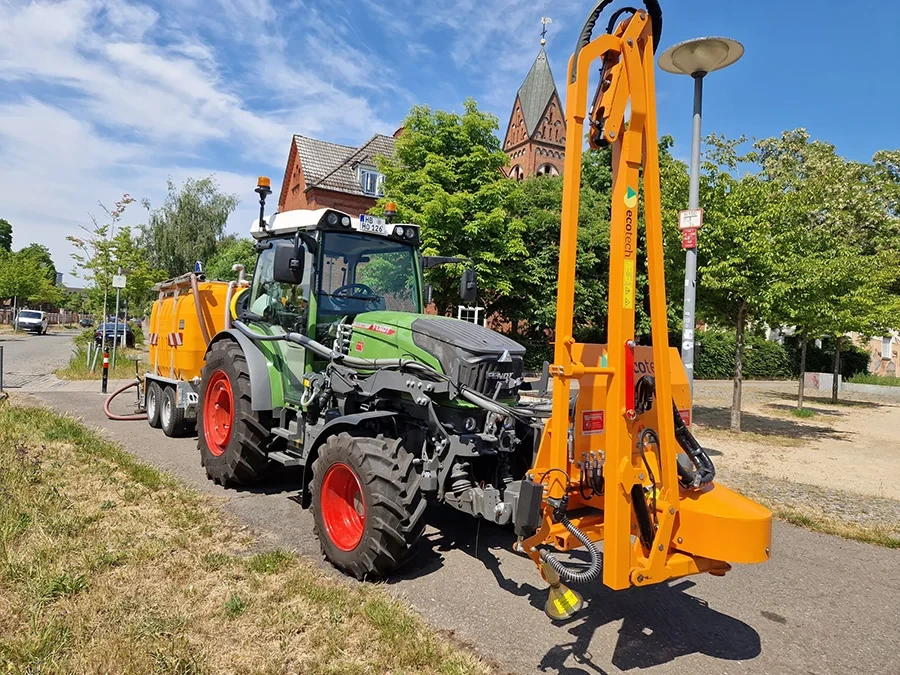 Mulchraupe im Einsatz auf einer Straße vor einer Kirche mit Fendt Traktor und Anbaugerät