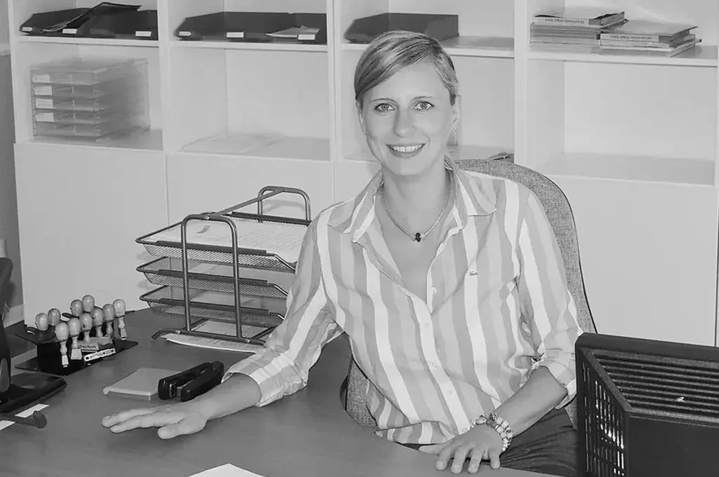 Kisten Sehmisch am Schreibtisch im Büro, Headerbild in Schwarzweiß