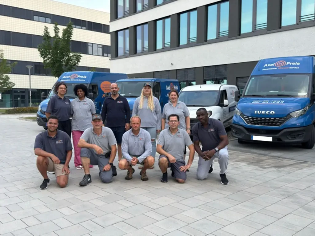 Team mit Fuhrpark und Firmenfahrzeugen vor dem Firmengebäude Teamfoto vor dem Fuhrpark mit mehreren Firmenfahrzeugen