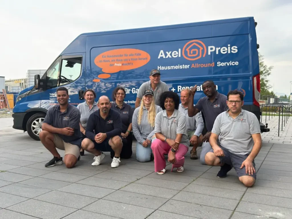 Team Axel Preis Hausmeister Allround Service mit Fuhrpark Team von Axel Preis Hausmeister Allround Service kniend vor dem Firmenfahrzeug