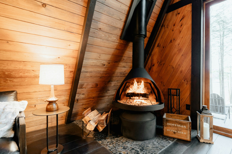 Effektives Kaminholz für gemütliche Abende Gemütlicher Innenraum mit brennendem Kamin und Holzstapel