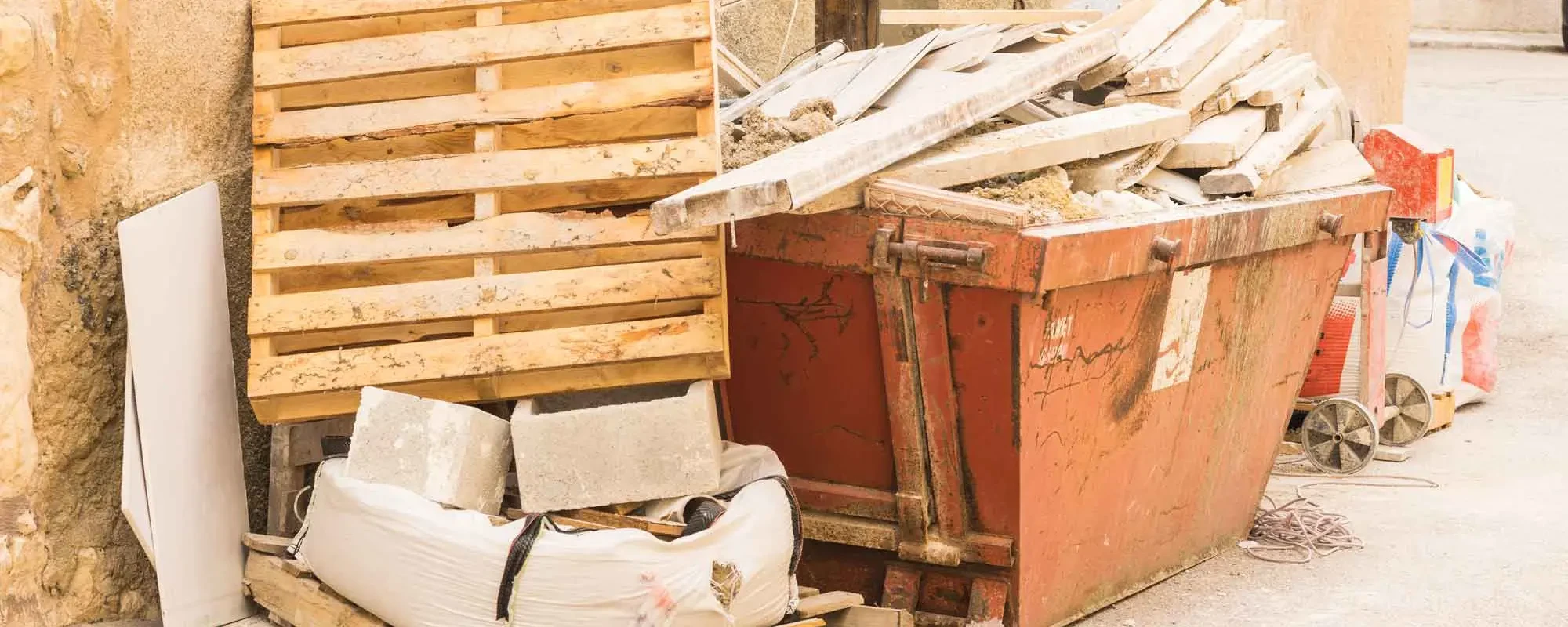 Container mit Bauschutt und Holzpaletten bei einer Entkernung